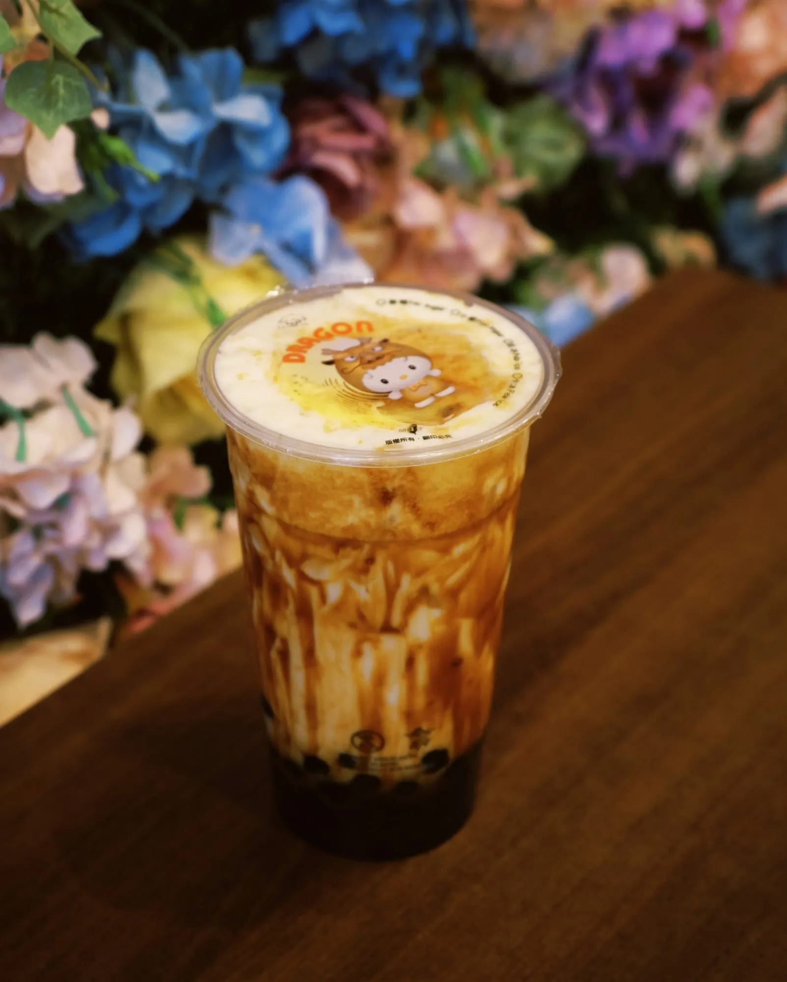 Bubble tea brown sugar devant le mur de fleurs de Sweet Bubble Thé