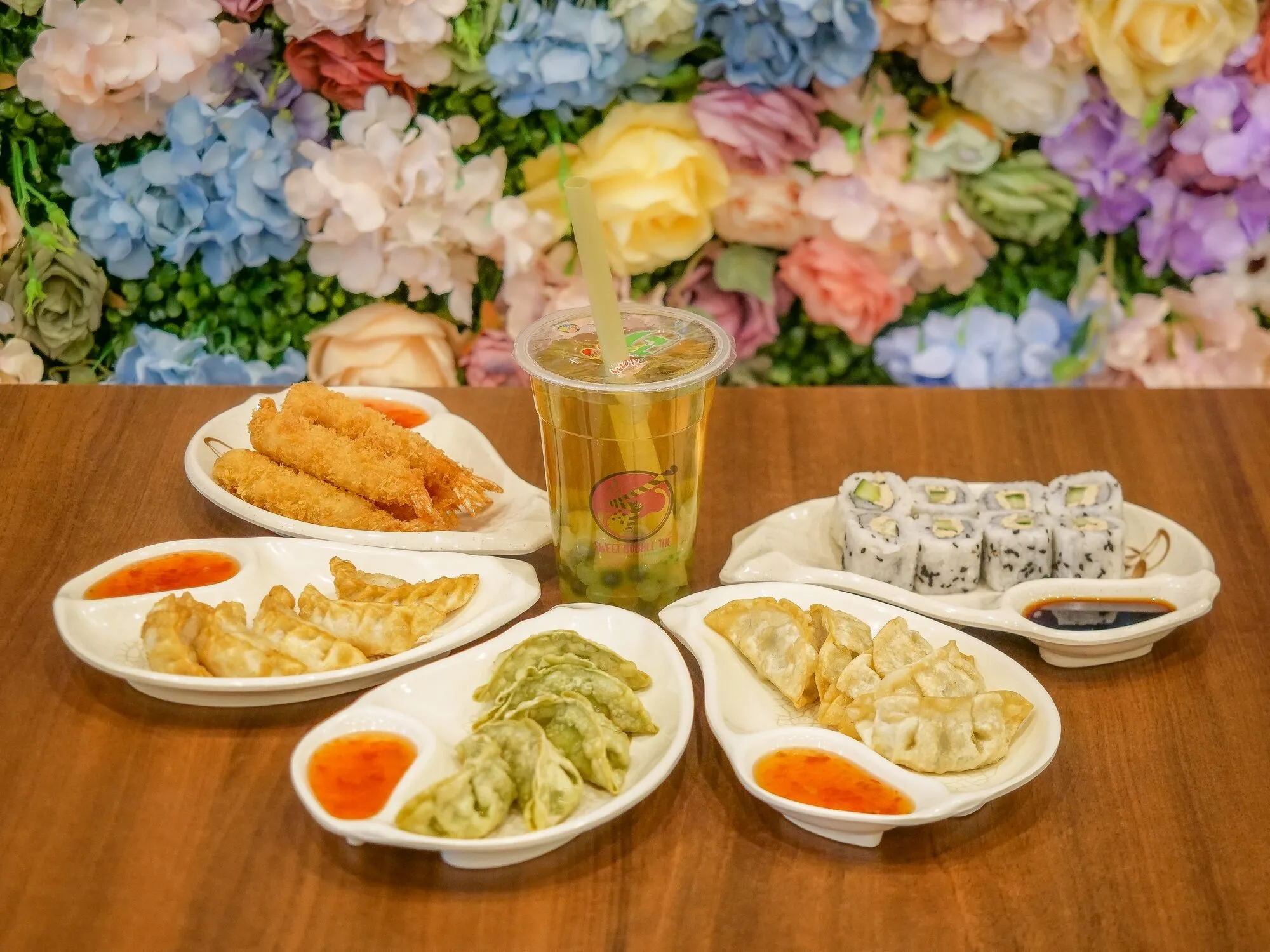 Plateau de gyozas, nems et makis servi avec un bubble tea