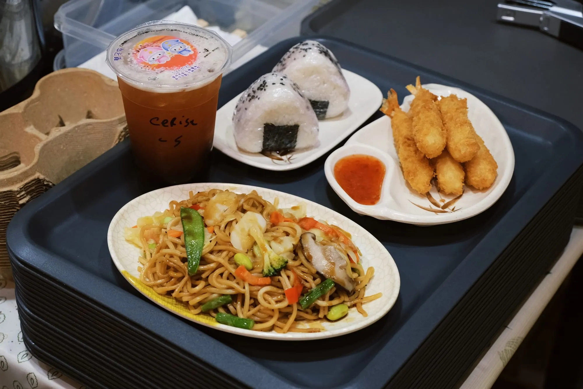 Plateau garni d’onigiris, de crevettes tempura et de yakisoba